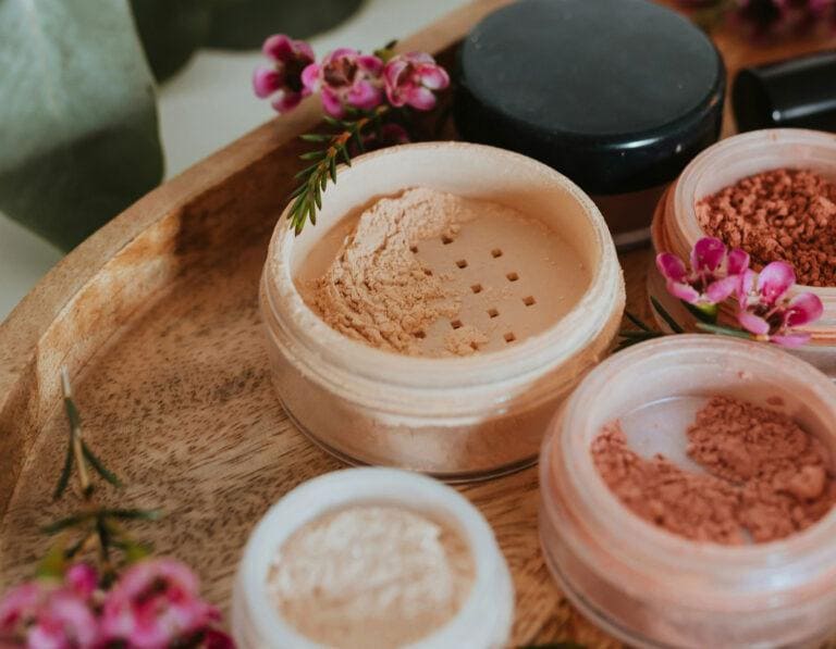 Cosmetics products arranged on a neutral background