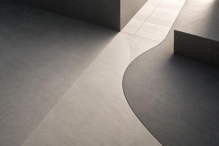Minimalist architectural scene showing smooth, light and dark tiled surfaces with sharp geometric lines and curves—much like a platform comparison between WordPress and Shopify—intersecting shadows, and angular structures create a modern, abstract composition. | Terrain